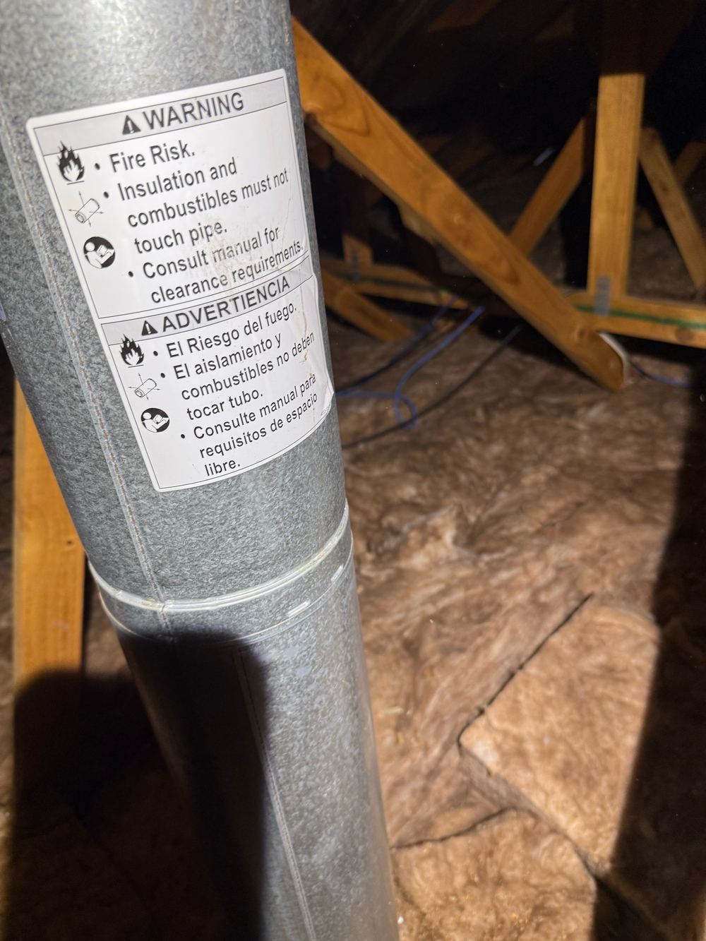 Fireplace flue touching roof insulation, a fire hazard, found during a defect investigation in Berwick