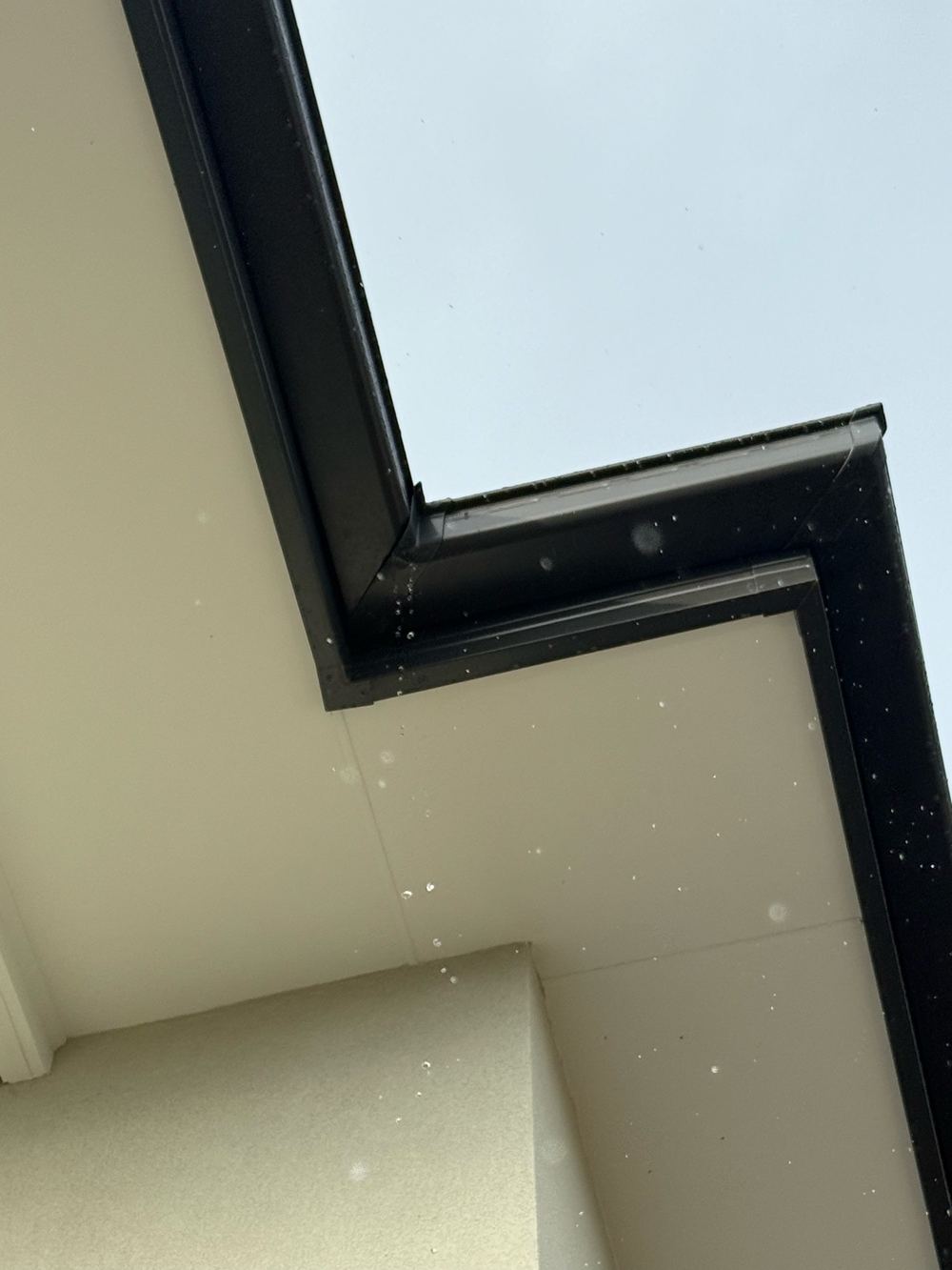 Gutter leaking at an internal corner during rain, found during a pre-handover inspection in Berwick